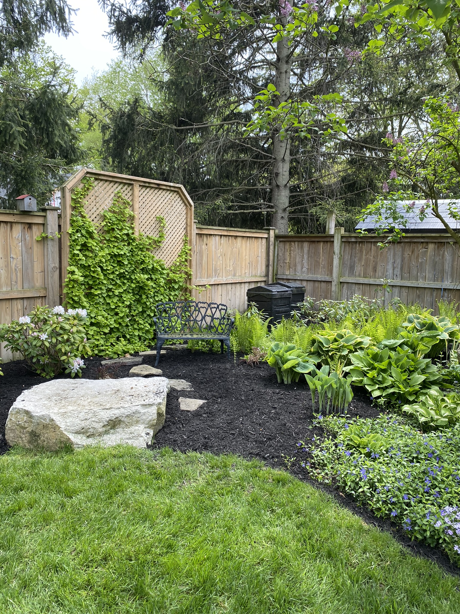 Private garden sanctuary with bench and natural boulder