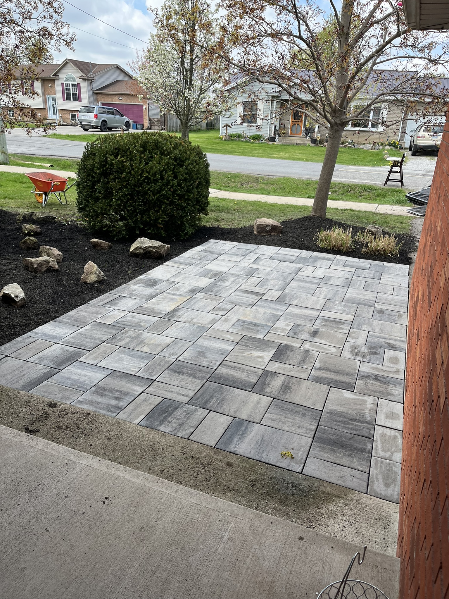 Hand-laid grey paver patio with planted garden beds