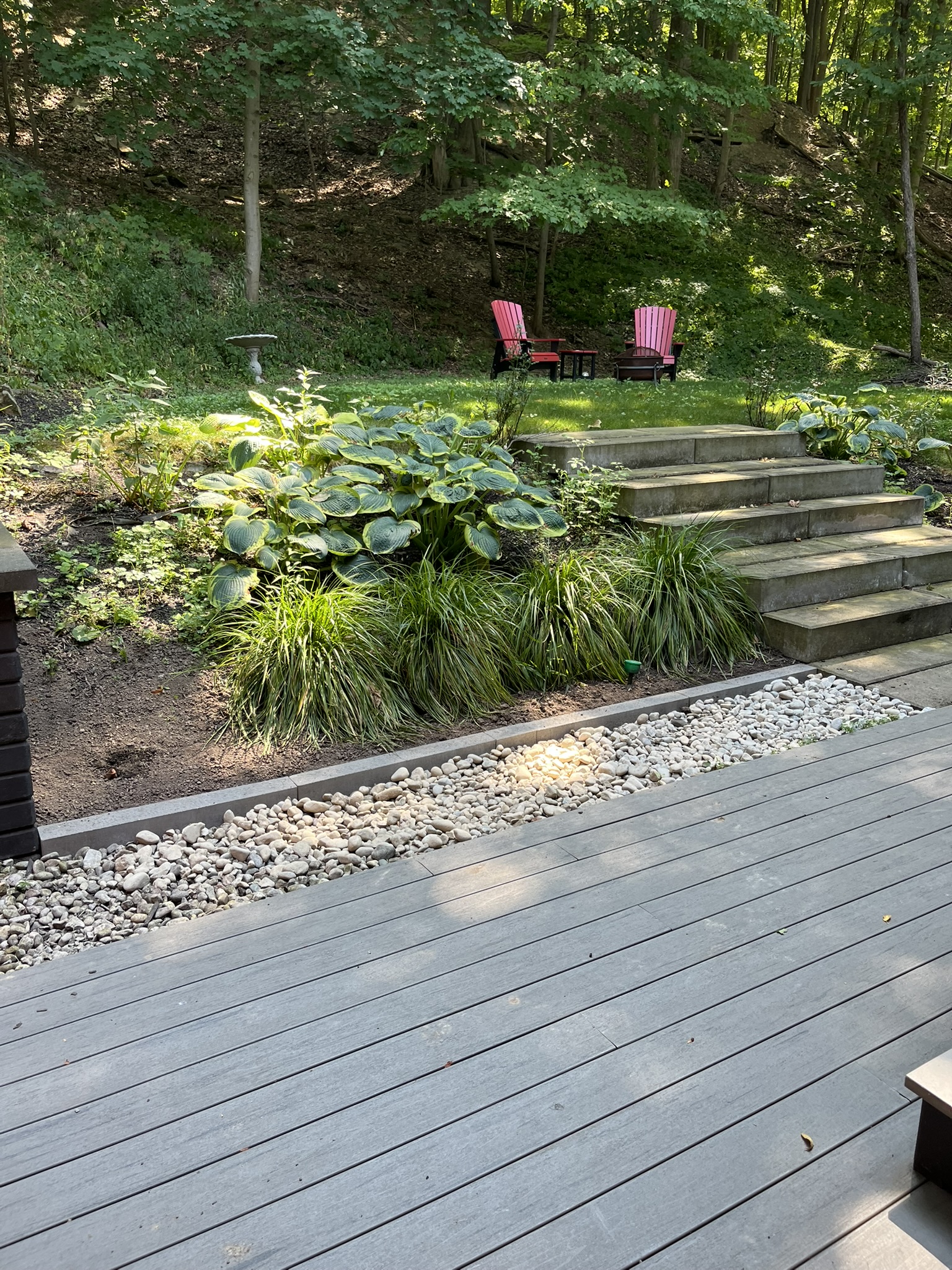 Composite deck and stone steps set into a wooded ravine