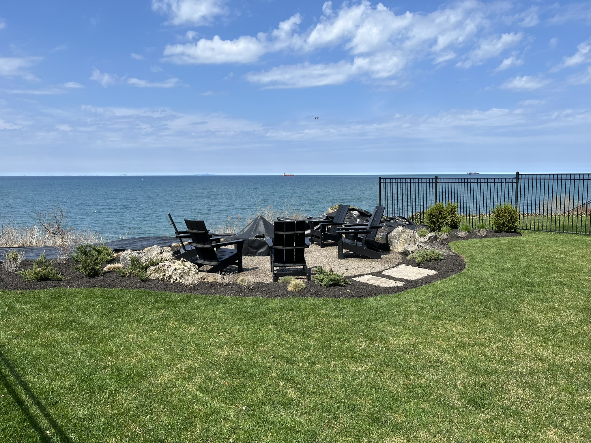 Lakefront fire-pit lounge with Adirondack chairs overlooking the water