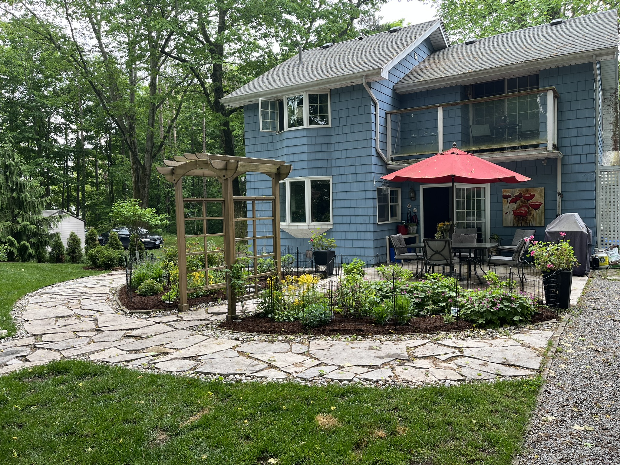 Flagstone patio path with a pergola arbor and dining set